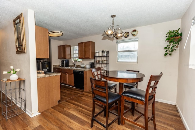 kitchen featuring dishwasher, dark wood-type flooring, a textured ceiling, and a chandelier