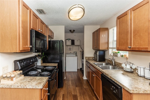 kitchen featuring black appliances, a textured ceiling, dark hardwood / wood-style floors, washer / clothes dryer, and sink