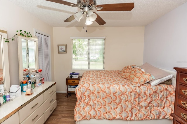 bedroom with multiple windows, hardwood / wood-style floors, ceiling fan, and a textured ceiling