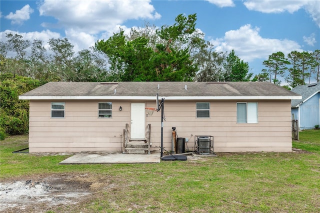 rear view of house with cooling unit and a yard