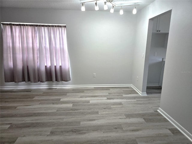 empty room with wood-type flooring and a textured ceiling