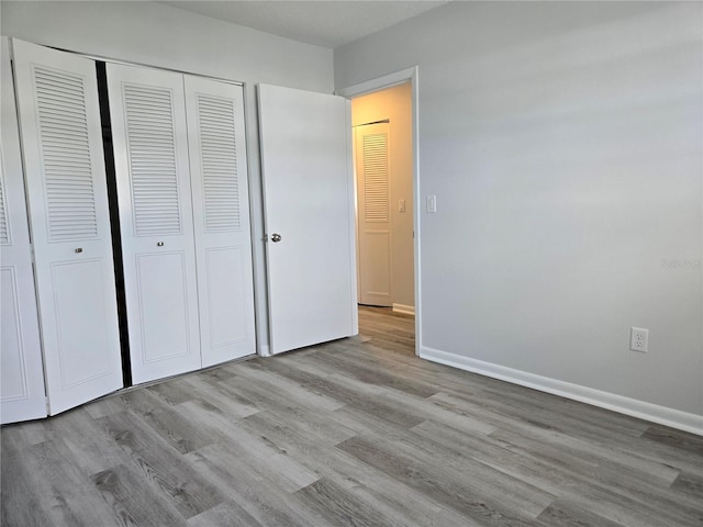 unfurnished bedroom featuring a closet and light hardwood / wood-style floors