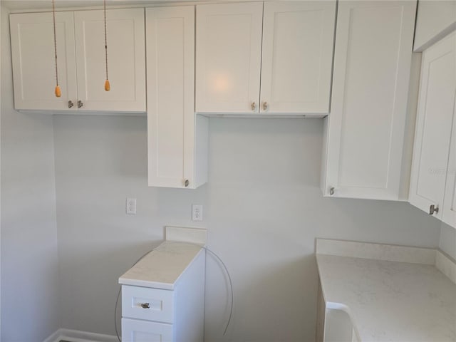 kitchen featuring white cabinets and light stone counters