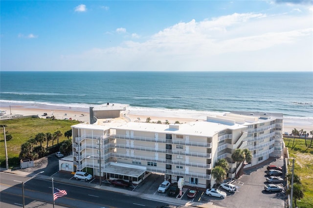 drone / aerial view with a beach view and a water view