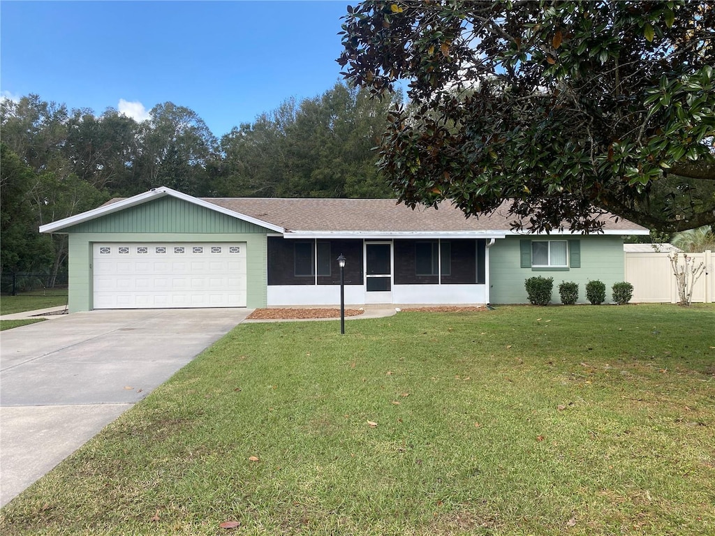 single story home featuring a garage, a front lawn, and a sunroom