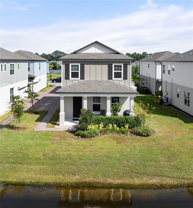 view of front facade featuring central AC, a water view, and a front yard