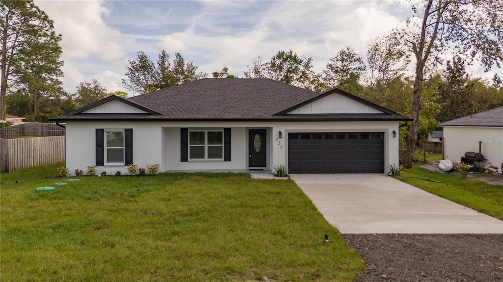 single story home featuring a garage and a front lawn