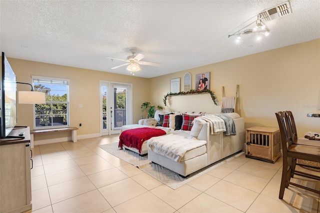 bedroom featuring a textured ceiling, access to outside, ceiling fan, and light tile patterned flooring