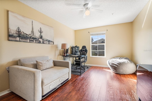 living area featuring a textured ceiling, dark hardwood / wood-style flooring, and ceiling fan