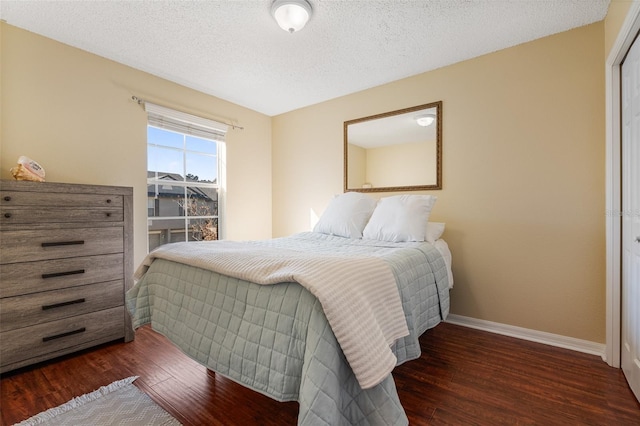 bedroom featuring dark hardwood / wood-style flooring and a textured ceiling