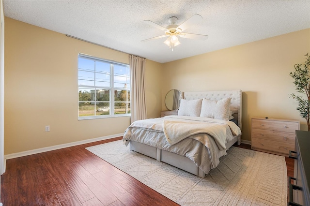 bedroom featuring ceiling fan, light wood-type flooring, and a textured ceiling