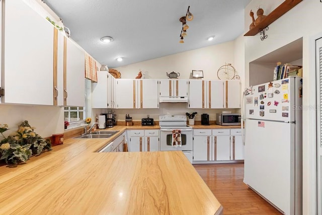 kitchen featuring white appliances, sink, vaulted ceiling, and white cabinets