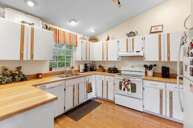 kitchen with sink, white appliances, vaulted ceiling, and white cabinets