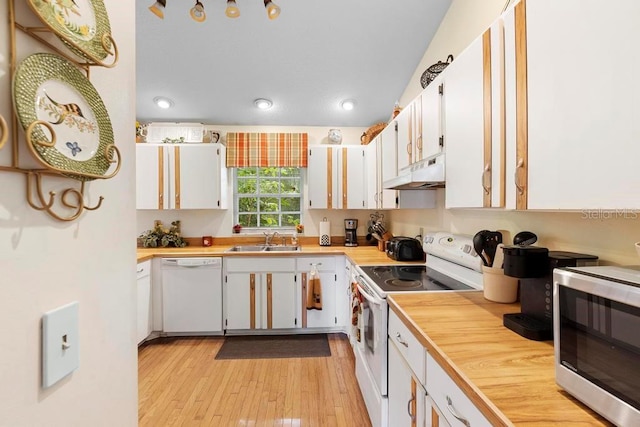 kitchen with light hardwood / wood-style flooring, white appliances, sink, and white cabinets