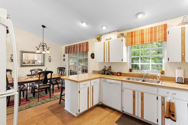 kitchen with decorative light fixtures, white dishwasher, sink, light hardwood / wood-style floors, and white cabinets