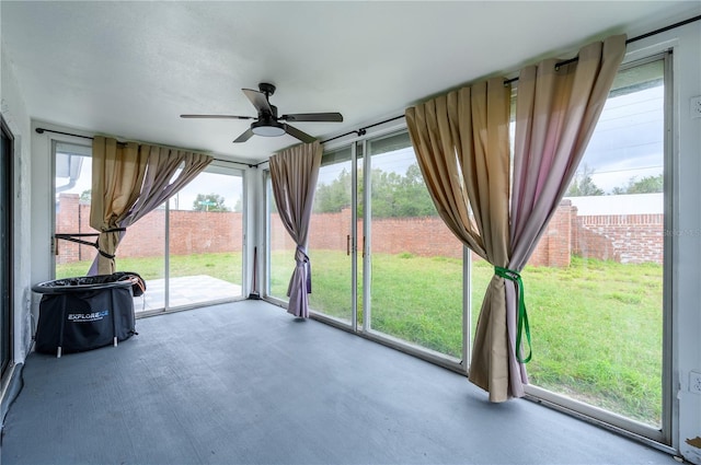 unfurnished sunroom with a healthy amount of sunlight and ceiling fan