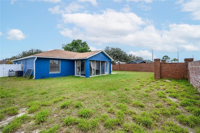 1171 Daimler Dr, Apopka, FL 32712 - back of property featuring a sunroom, stucco siding, and central AC unit