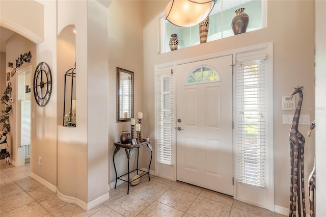 foyer featuring a towering ceiling and light tile patterned floors