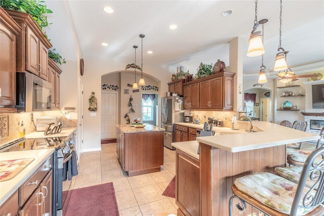 kitchen with kitchen peninsula, decorative light fixtures, backsplash, and stainless steel appliances