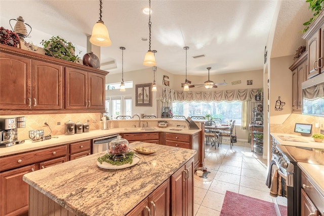 kitchen with tasteful backsplash, a kitchen island, stainless steel appliances, and decorative light fixtures