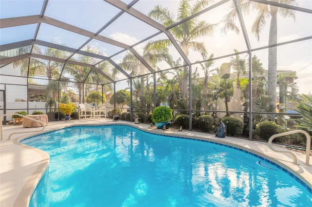 view of pool featuring glass enclosure and a patio area