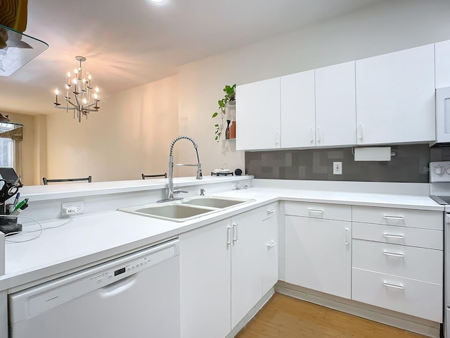 kitchen featuring white dishwasher, hanging light fixtures, a notable chandelier, white cabinets, and light wood-type flooring