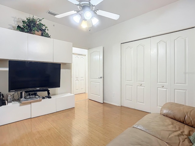 living room featuring light wood-type flooring and ceiling fan