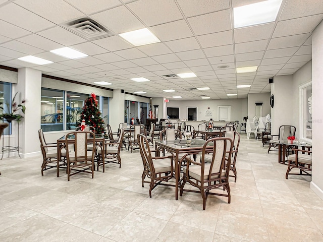 tiled dining space featuring a paneled ceiling