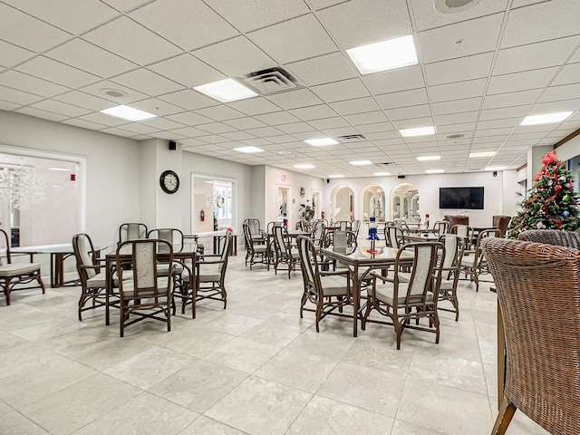 tiled dining area featuring a drop ceiling