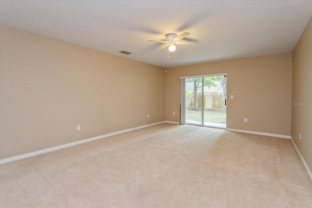 carpeted spare room featuring ceiling fan