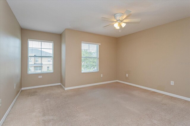 carpeted empty room featuring ceiling fan and a healthy amount of sunlight