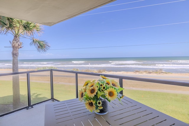 balcony featuring a beach view and a water view