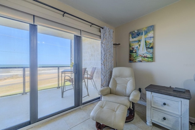 living area with light tile patterned floors and a water view