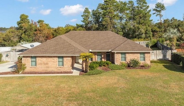 ranch-style home featuring brick siding, a front yard, and fence