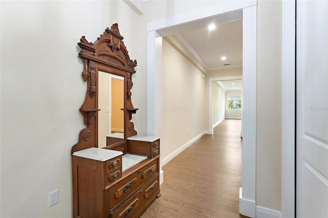 hall with light hardwood / wood-style flooring and crown molding