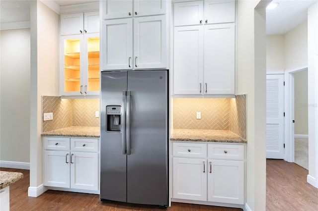 kitchen with white cabinetry, light stone countertops, hardwood / wood-style flooring, and stainless steel fridge