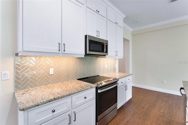 kitchen featuring stainless steel appliances, white cabinetry, ornamental molding, light stone countertops, and dark hardwood / wood-style floors