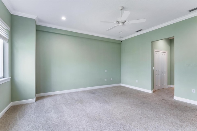 carpeted spare room with ceiling fan and ornamental molding