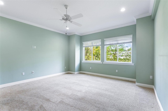 spare room featuring light colored carpet, ceiling fan, and crown molding