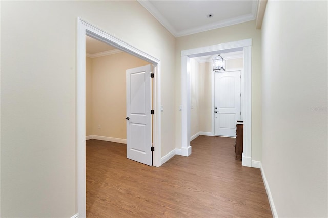 hall with light hardwood / wood-style floors and crown molding