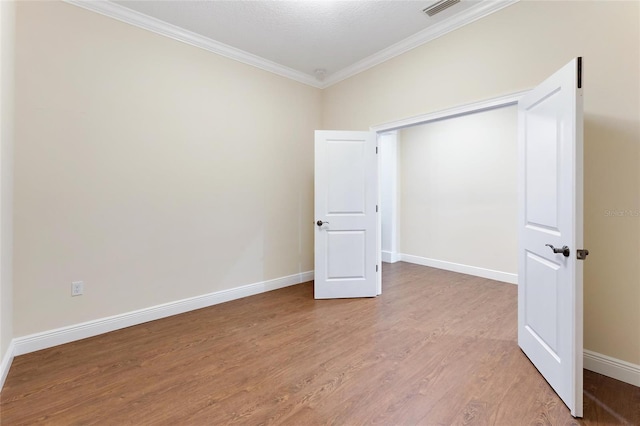 unfurnished bedroom with hardwood / wood-style flooring and ornamental molding