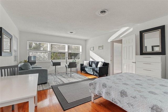 bedroom featuring wood-type flooring and a textured ceiling