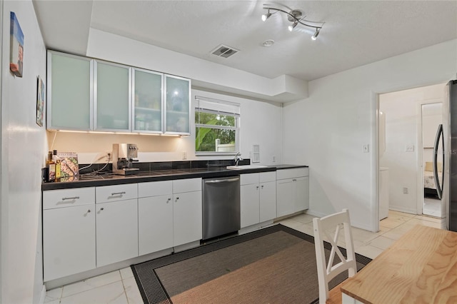 kitchen with white cabinets, sink, light tile patterned floors, and stainless steel appliances