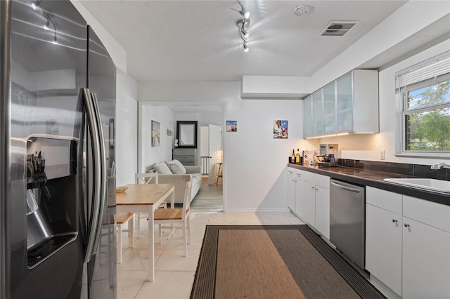 kitchen featuring white cabinetry, sink, rail lighting, and stainless steel appliances