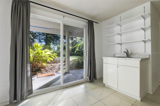 doorway featuring a textured ceiling and sink