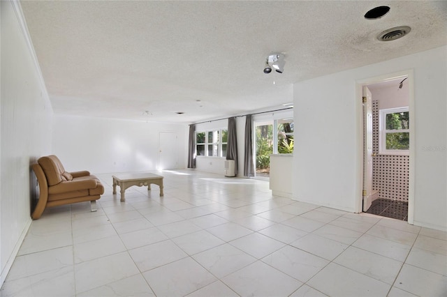 unfurnished room with light tile patterned floors and a textured ceiling