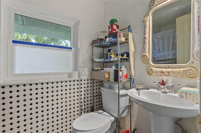 bathroom featuring sink, plenty of natural light, toilet, and tile walls