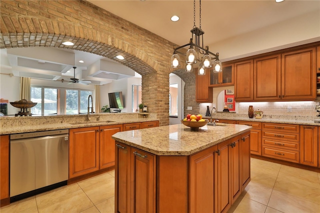 kitchen with dishwasher, sink, a kitchen island with sink, pendant lighting, and brick wall