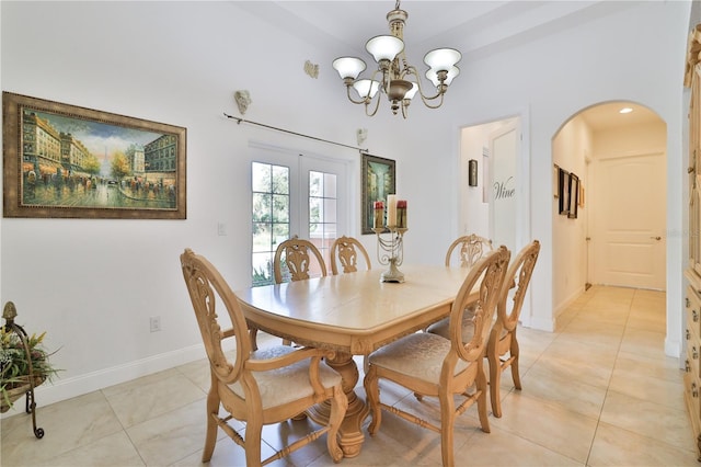 dining space with light tile patterned floors, french doors, and a notable chandelier