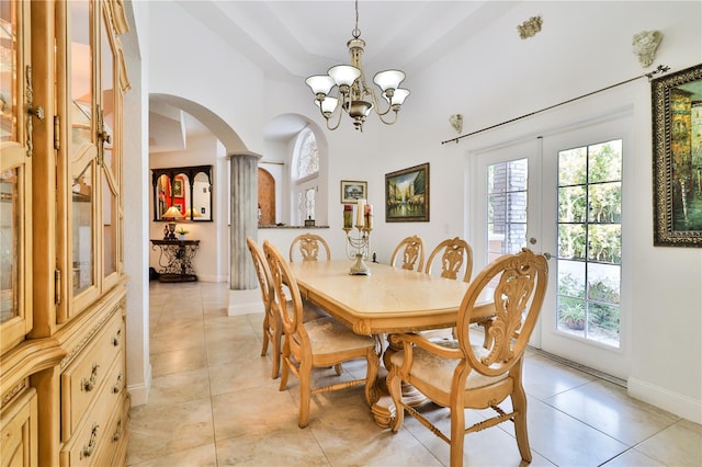 dining room with french doors, a chandelier, decorative columns, and light tile patterned floors